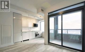 Vaughan (Concord) condo for rent - A modern kitchen with white cabinets and a large window.