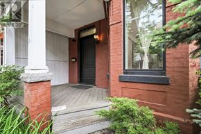 Toronto (Roncesvalles) apartment for rent - A red brick house with a black door and a small porch.