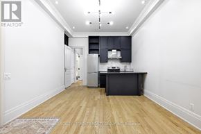 Toronto (Roncesvalles) apartment for rent - A kitchen with a refrigerator, oven, and microwave in a white room with wooden floors.