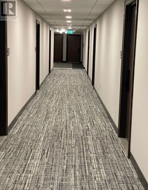 Kitchener condo for rent - A hallway with a carpeted floor and doors on both sides.