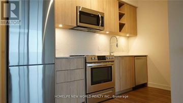 Toronto (Niagara) condo for rent - A modern kitchen with wooden cabinets and stainless steel appliances.