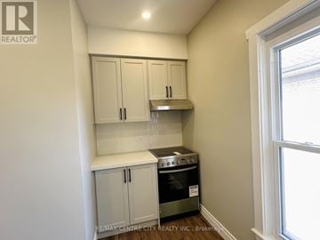 St. Thomas fourplex for rent - A small kitchen with a stove and cabinets.