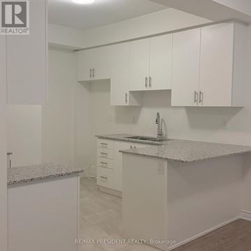 Brampton (Northwest Brampton) townhouse for rent - A kitchen with white cabinets and a marble countertop.