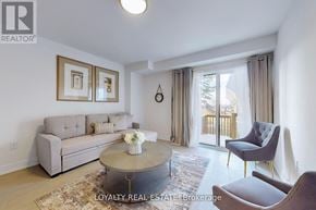 Toronto (Downsview-Roding-Cfb) townhouse for rent - A living room with a grey couch, a coffee table, and a chair.