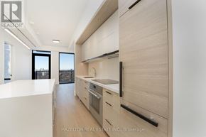 Toronto (Forest Hill South) condo for rent - A modern kitchen with wooden cabinets and a white countertop.