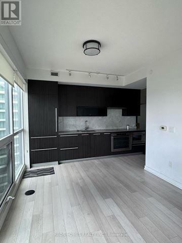 Toronto (Bayview Village) condo for rent - A kitchen with a black counter top and white walls.