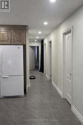 Toronto (Pleasant View) apartment for rent - A white refrigerator in a kitchen with wooden cabinets.