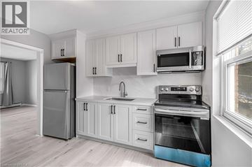 Kitchener apartment for rent - A kitchen with white cabinets and a stainless steel oven.