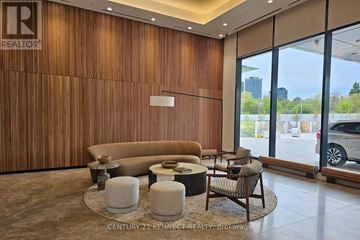 Toronto (Bayview Village) condo for rent - A modern living room with a brown sofa and a wooden wall.