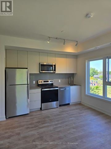 St. Catharines (E. Chester) townhouse for rent - A kitchen with a refrigerator, microwave, oven, and cabinets.