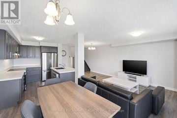 Hamilton townhouse for rent - A modern living room with a wooden table and grey couch.