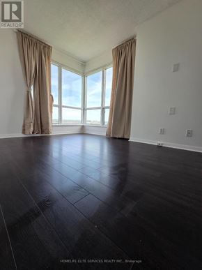 Toronto (Woburn) condo for rent - A room with a large window and a wooden floor.