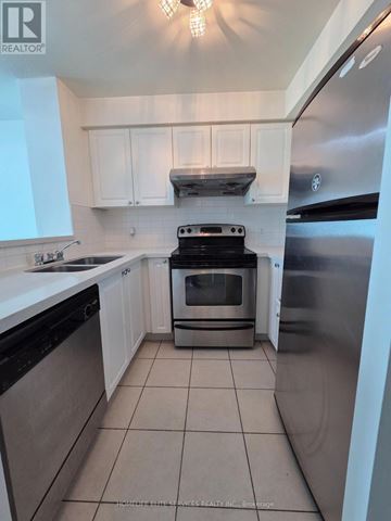 Toronto (Woburn) condo for rent - A kitchen with white cabinets and a stainless steel refrigerator.