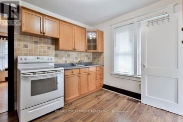 Mississauga (Streetsville) apartment for rent - A kitchen with wooden cabinets and a white stove top oven.