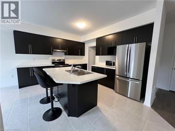 Paris apartment for rent - A modern kitchen with black cabinets and a center island.