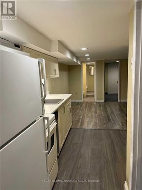 Toronto (Danforth) apartment for rent - A kitchen with a white refrigerator and wooden floors.