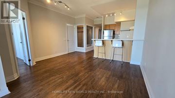 Toronto (Willowdale East) condo for rent - A spacious living room with hardwood floors and a kitchen area in the background.