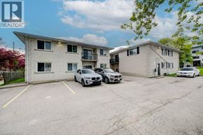 Waterloo apartment for rent - A parking lot with two cars and apartment buildings in the background.