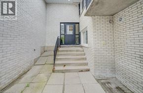 Waterloo apartment for rent - A white brick building with a black door and a small window.