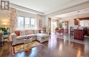 Niagara Falls (Oldfield) apartment for rent - A well-lit living room with a white sofa and a wooden floor.