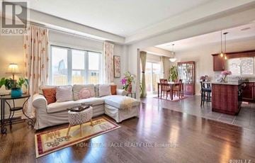 Niagara Falls (Oldfield) apartment for rent - A well-lit living room with a white sofa and a wooden floor.