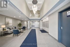 Welland (Lincoln/Crowland) multi-family for rent - A hallway with a blue carpet and a chandelier hanging from the ceiling.