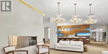 Toronto (Mimico) condo for rent - A modern living room with a white sofa and a fireplace.