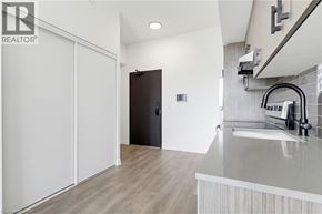 Burlington condo for rent - A modern kitchen with a sink and a black door.