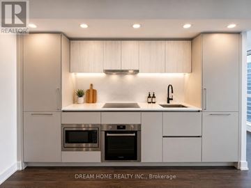 Toronto (North St. James Town) condo for rent - A modern kitchen with white cabinets and stainless steel appliances.