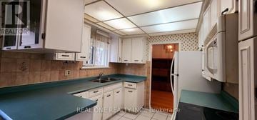 Toronto (Woburn) apartment for rent - A kitchen with white cabinets and a green countertop.