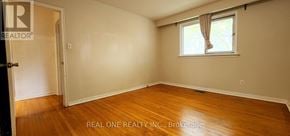 Toronto (Woburn) apartment for rent - A room with wooden floors and a window with curtains.