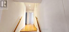 Toronto (Woburn) apartment for rent - A hallway with a wooden staircase and white walls.
