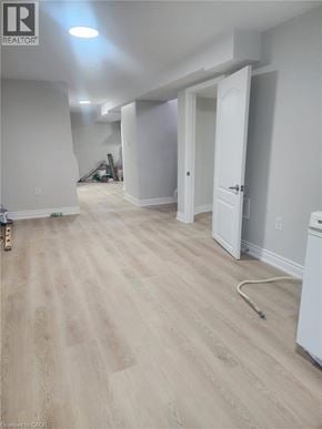 Kitchener apartment for rent - A room with wood flooring and white walls, with a door open to another room.