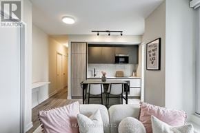 Toronto (Waterfront Communities) condo for rent - A modern living room with a kitchen in the background.