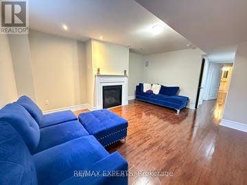 Ajax (Northeast Ajax) apartment for rent - A living room with a blue couch and a fireplace.