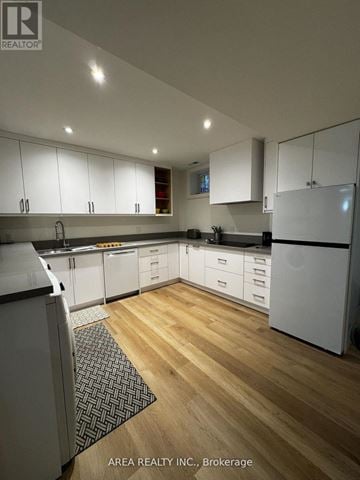 Mississauga (Lorne Park) apartment for rent - A modern kitchen with white cabinets and wooden flooring.