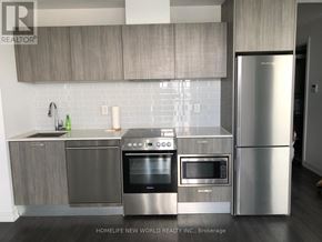 Toronto (Church-Yonge Corridor) condo for rent - A modern kitchen with stainless steel appliances and wooden cabinets.