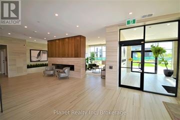 Guelph (Pineridge/Westminster Woods) condo for rent - A modern living room with a fireplace and a large painting on the wall.