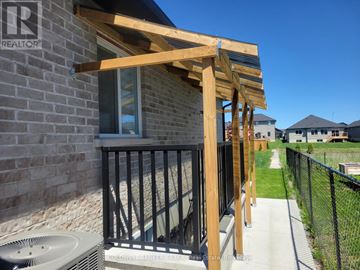 Belleville (Thurlow Ward) apartment for rent - A wooden pergola attached to a brick building with a sign that says REALTOR.