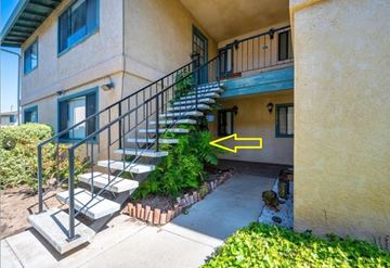 Grover Beach apartment for rent - A yellow arrow points to a small door on the side of a building.