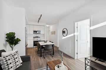 Surrey apartment for rent - A modern living room with a grey couch and a wooden coffee table.