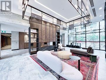 Toronto (Mimico) house for rent - A modern living room with a large sofa and a glass partition.