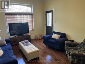 Blue Mountains multi-family for rent - A living room with a blue couch, a television, and a patterned chair.