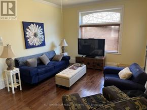 Blue Mountains multi-family for rent - A living room with a blue couch, a white side table, and a television.