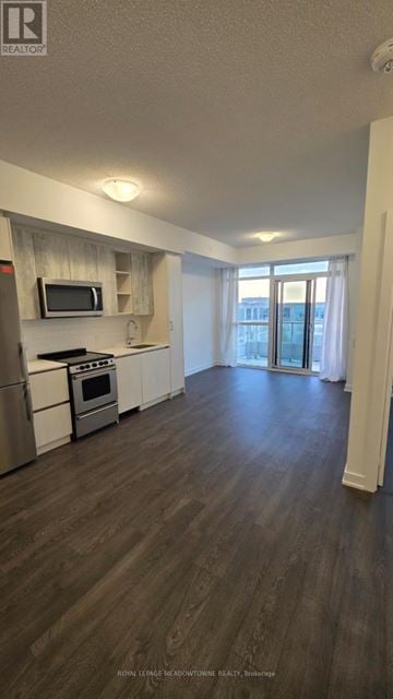 Toronto (Mimico) condo for rent - A kitchen with a stove top oven and a microwave.