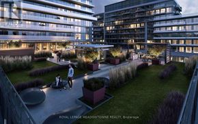 Toronto (Mimico) condo for rent - A modern building with a well-maintained garden in front.