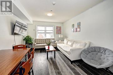Waterloo condo for rent - A living room with a white couch and a wooden table.