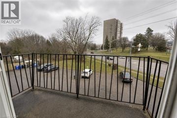 Waterloo apartment for rent - A black metal fence surrounds a parking lot.