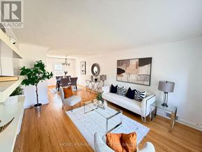 Toronto (Wexford-Maryvale) apartment for rent - A living room with a white couch, a coffee table, and a plant.
