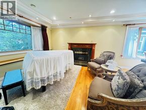 Vancouver apartment for rent - A bedroom with a bed covered in a white bedspread, a fireplace, and a couch with pillows.